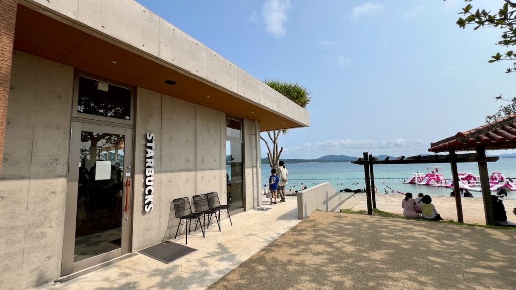 店舗入り口のアップ。重厚なコンクリート壁に「STARBUCKS」の白いロゴが映える。