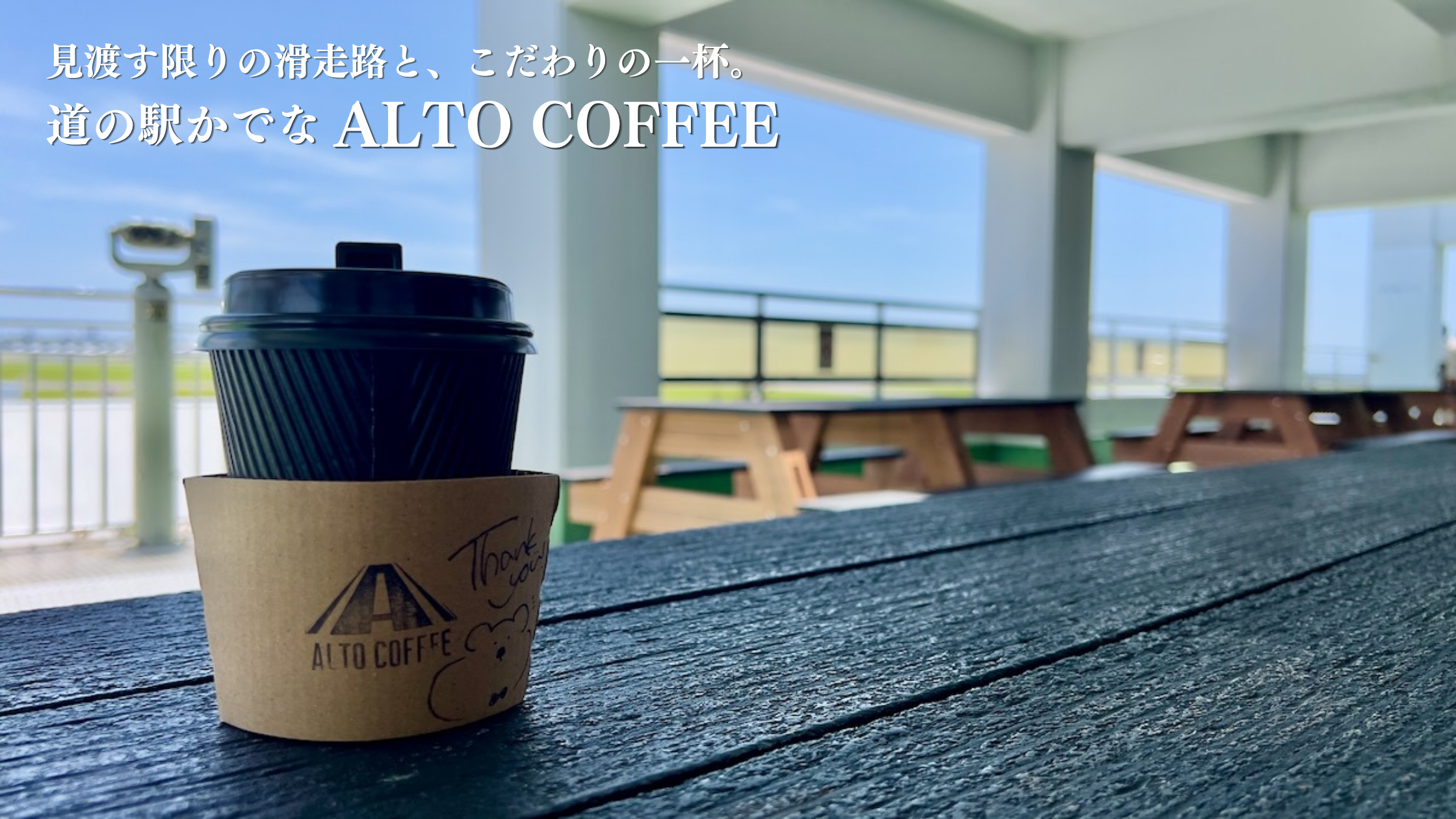道の駅かでなの展望デッキの木製テーブルに置かれたALTO COFFEEのカップと、背景に広がる嘉手納基地の滑走路