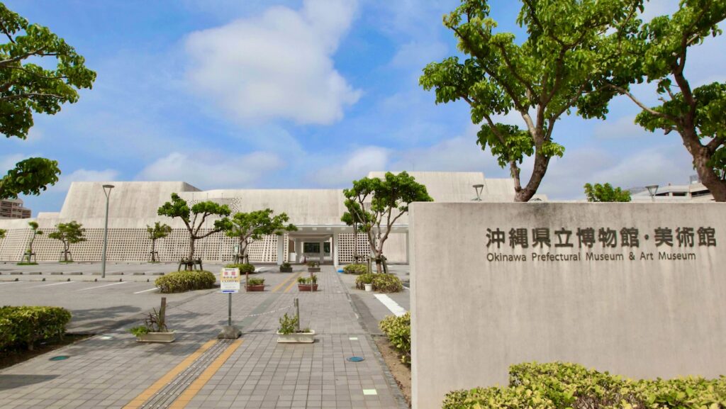 青空に映える真っ白な建築の沖縄県立博物館・美術館の外観と入り口