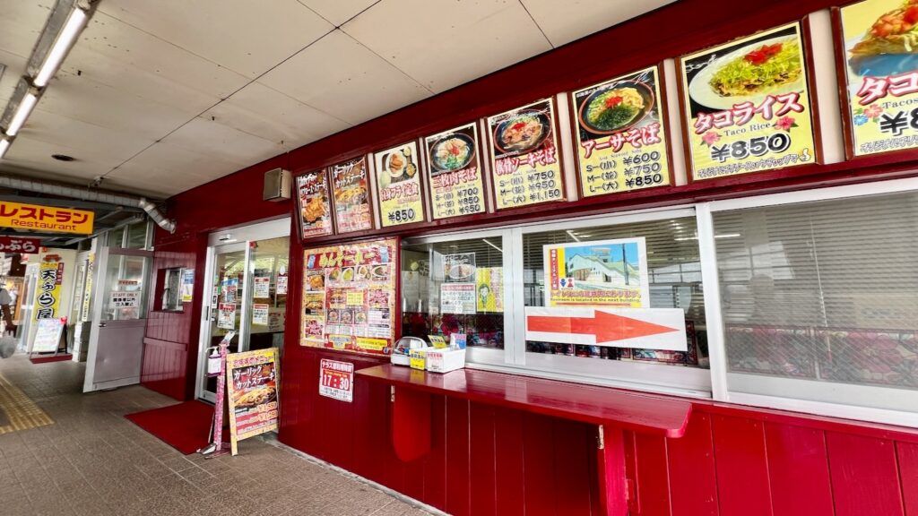 道の駅許田のフードコートの入り口と、外観に並ぶ看板