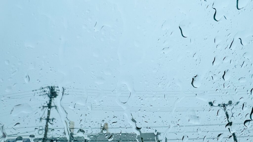 窓ガラスに雨粒がついている雨の日の風景