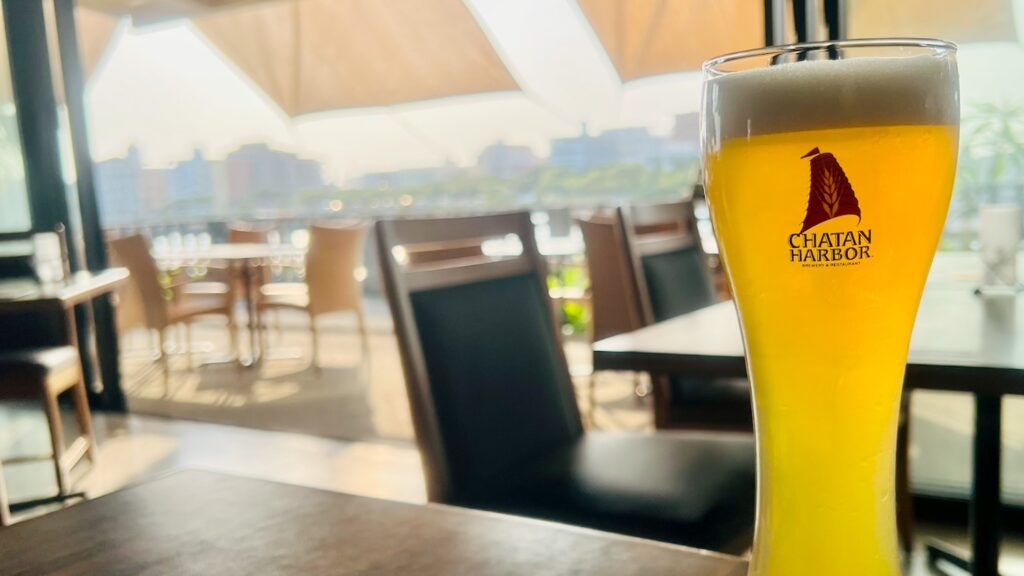 テラス席と店内席を背景に、美味しそうなビールがテーブルにあるチャタンハーバー ブルワリー＆レストランの店内風景