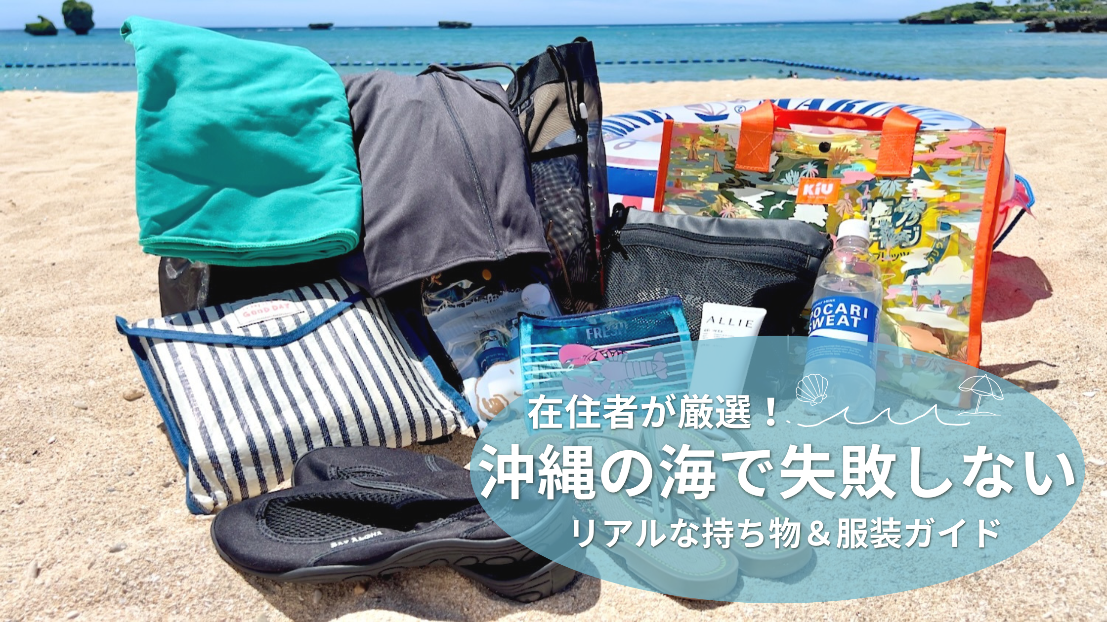 青い海を背景に、白い砂浜の上にビーチバックやレジャーシートなど海グッズが広がっている画像