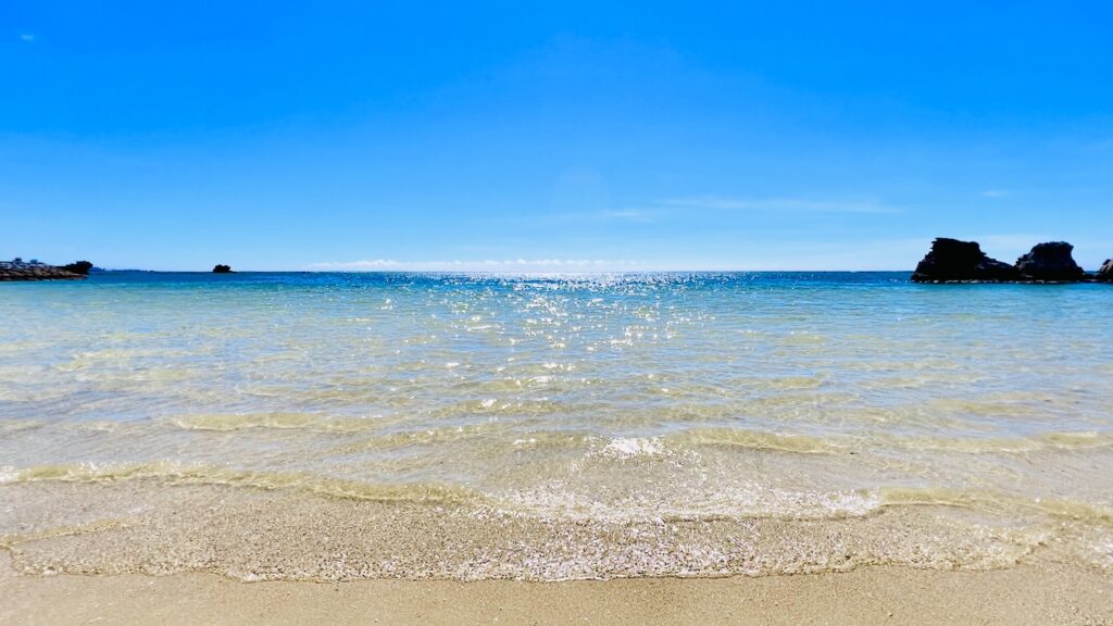 青空の下に透き通る水の海が広がる沖縄ビーチ