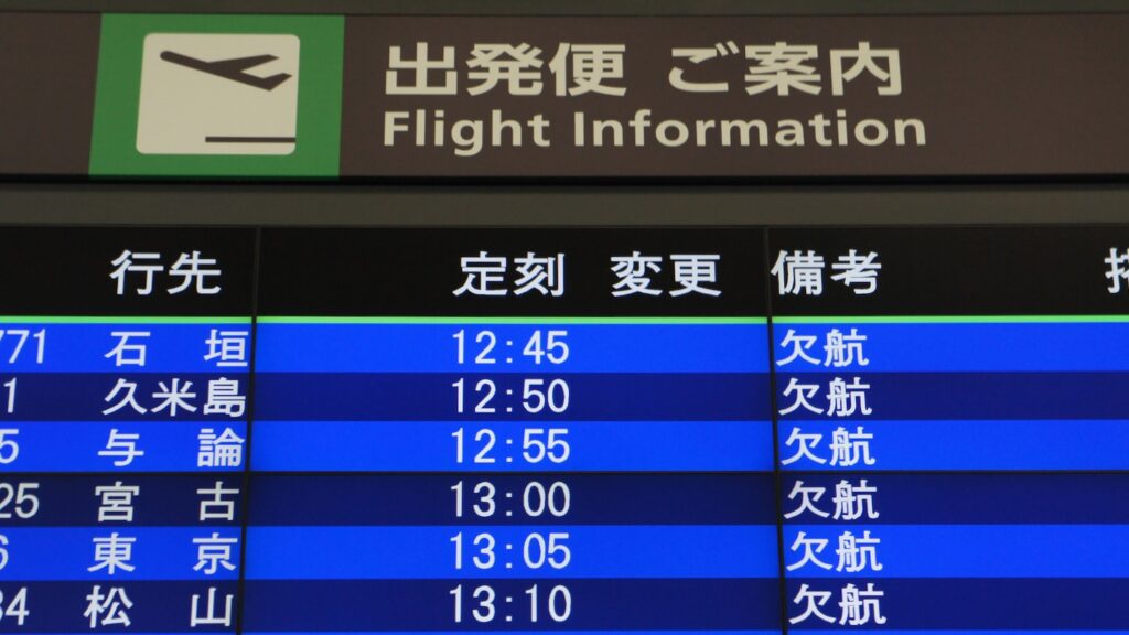 飛行機の出発便の案内板に欠航の文字が並んでいる画像