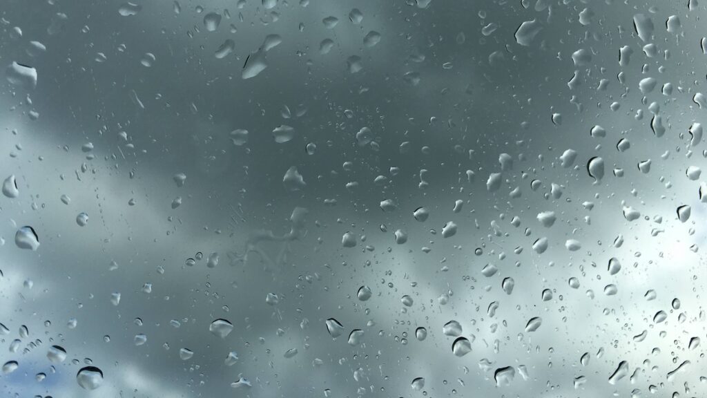 窓に雨粒が広がっている悪天候の風景