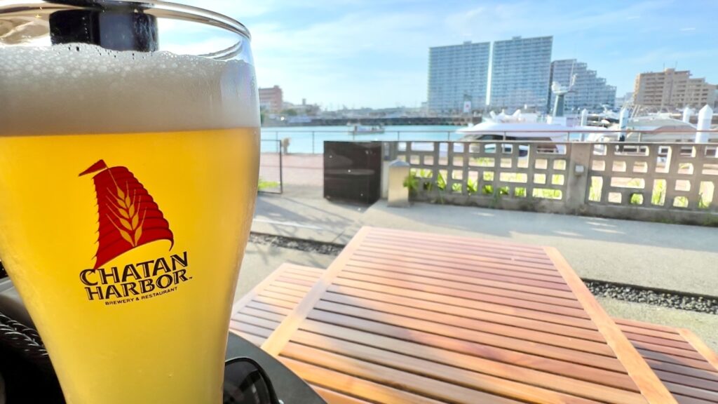 クルーザーが停泊しているハーバーとテラス席を背景に、美味しそうなビールがあるチャタンハーバー ブルワリー&レストランの店内風景