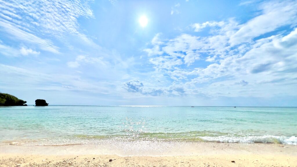 太陽が輝く青空と白い砂浜が広がるニライビーチ