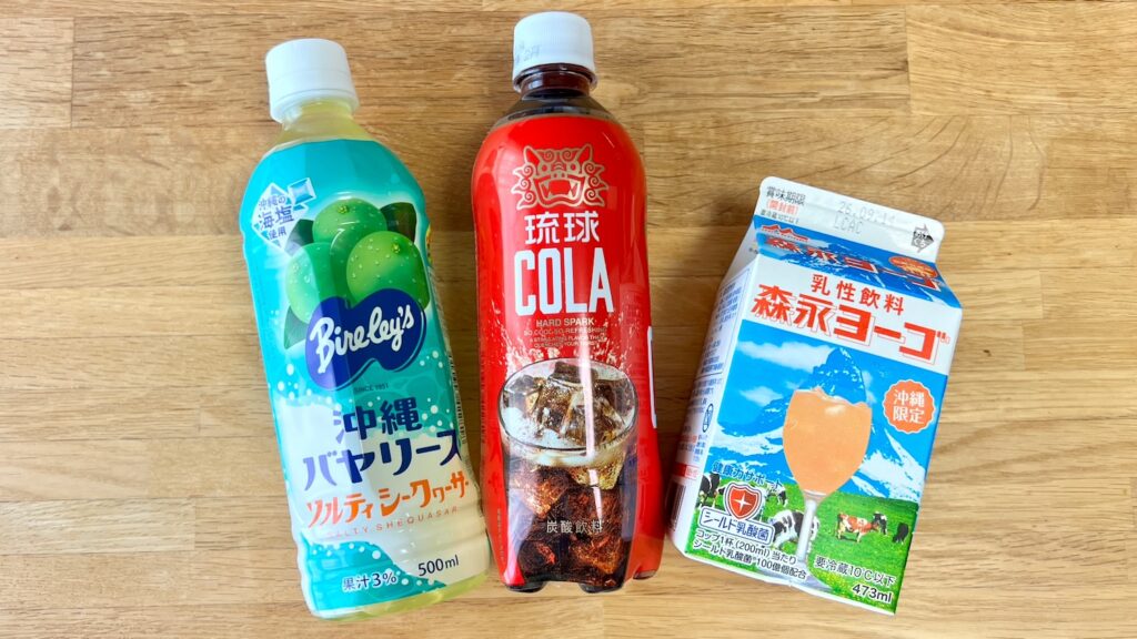 テーブルに沖縄バヤリースのソルティシークヮーサー味、琉球コーラ、森永ヨーゴが並んでいる画像