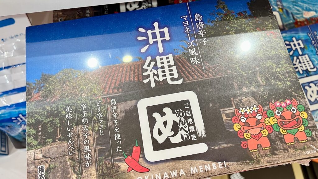 沖縄の古民家の写真とかわいいシーサーのイラストが描かれている「沖縄めんべい 島唐辛子マヨネーズ風味」のパッケージ