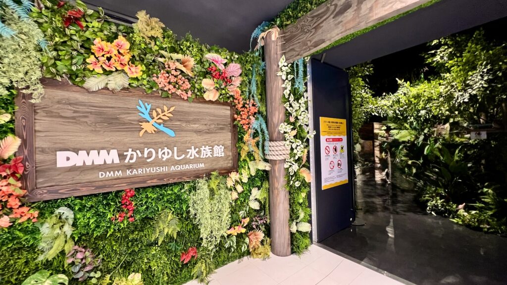 トロピカルなフェイクグリーンに囲まれたおしゃれな「DMM かりゆし水族館」のの展示エリア入り口